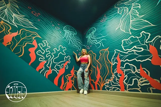 Interior con mural de línea blanca y coral sobre fondo teal